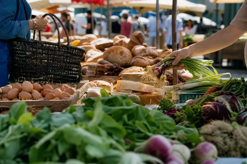Bread, cheese, eggs and vegetables on stalls at a summer food market