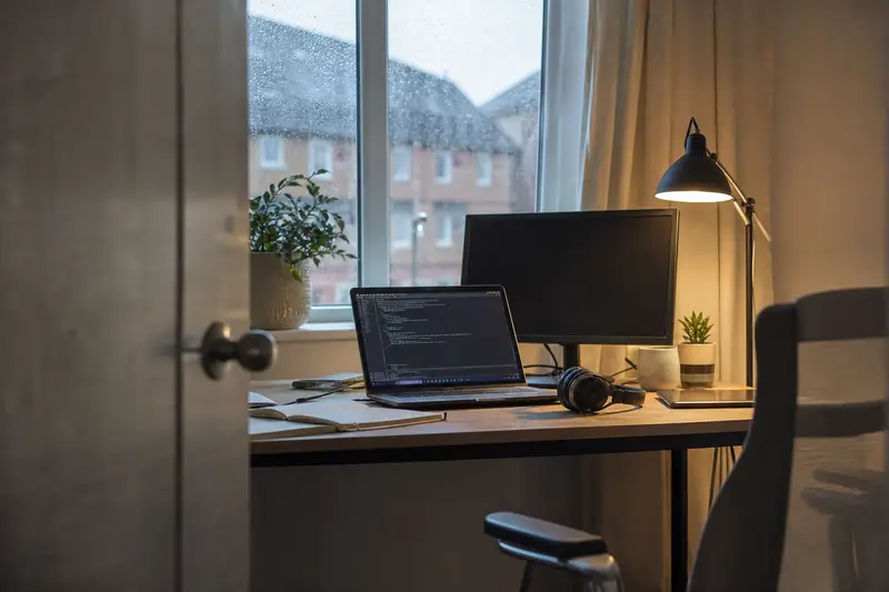 A freelance IT consultant's home office with a laptop and second monitor