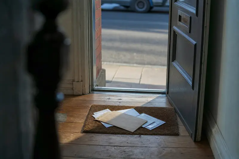 A brown envelope among the post on a doormat inside a front door